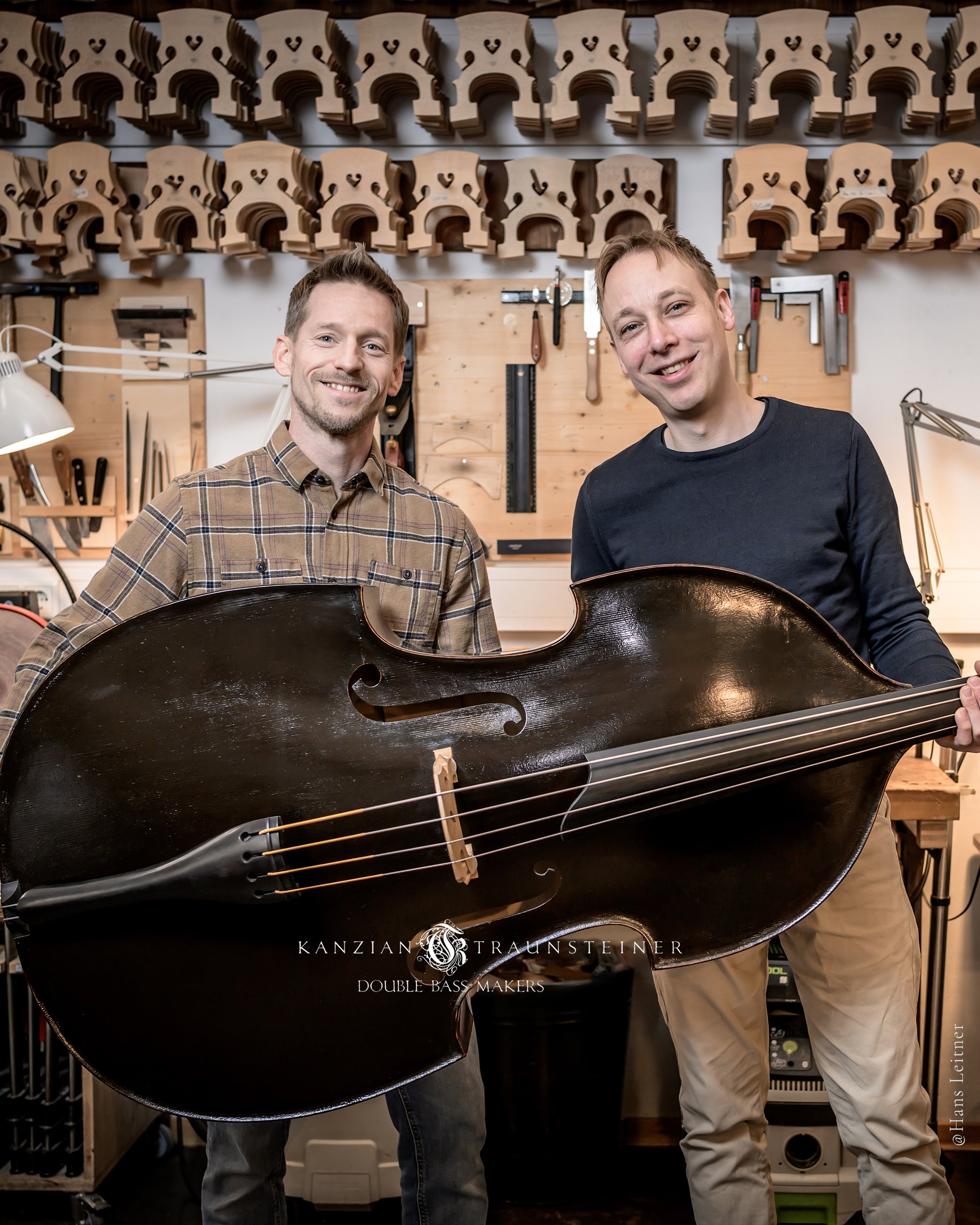 Kanzian & Traunsteiner holding their black Viennese model double bass